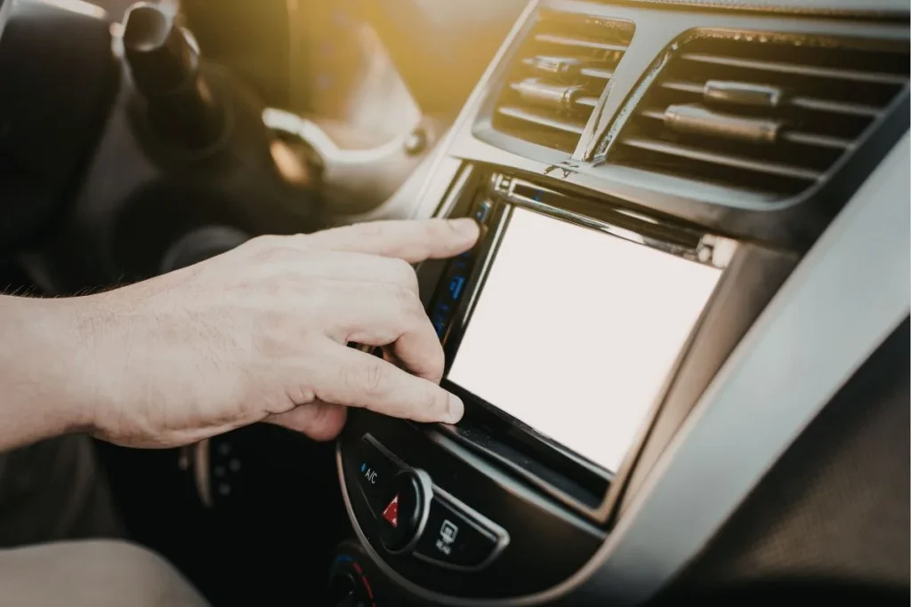 Driver turning on car A/C system in hot weather highlighting the connection between air conditioning and car cooling system repair