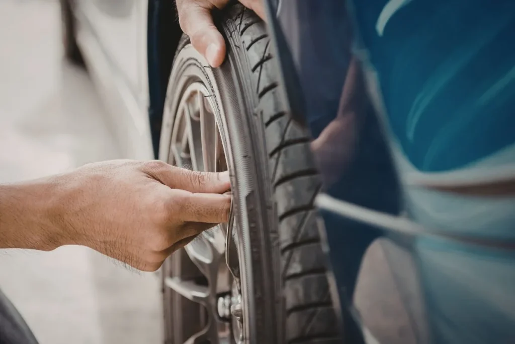 Mechanic inspecting car tire and wheel — wheel bearing repair cost